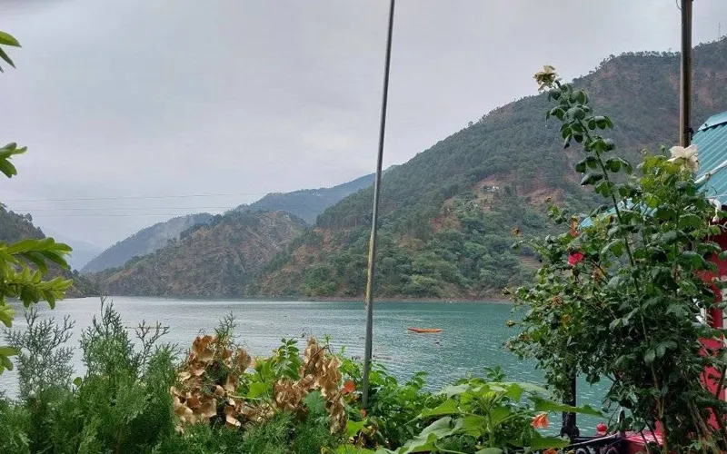Scenic view of turquoise waters of Chamera Lake surrounded by green hills near Dalhousie
