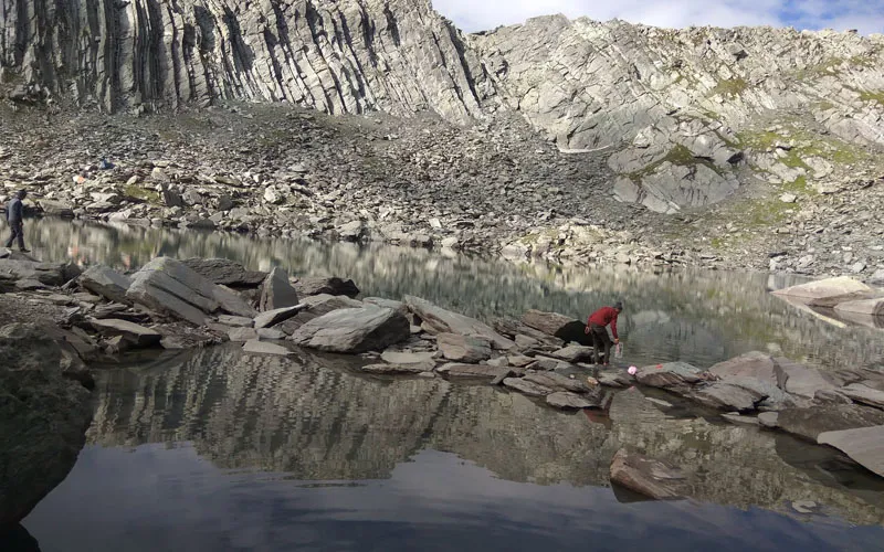 Pristine high-altitude glacial waters of Dehnasar Lake enclosed by rocky moraines