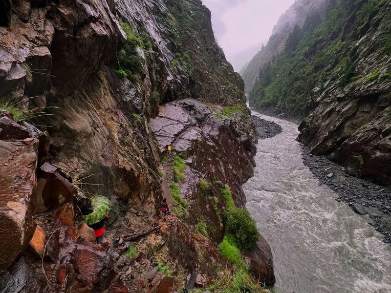 Fast-flowing mountain river cutting through steep, narrow rocky canyon along Bara Bhangal trek