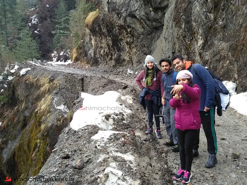 Trekking group navigating a rugged cliffside mountain path near Barot