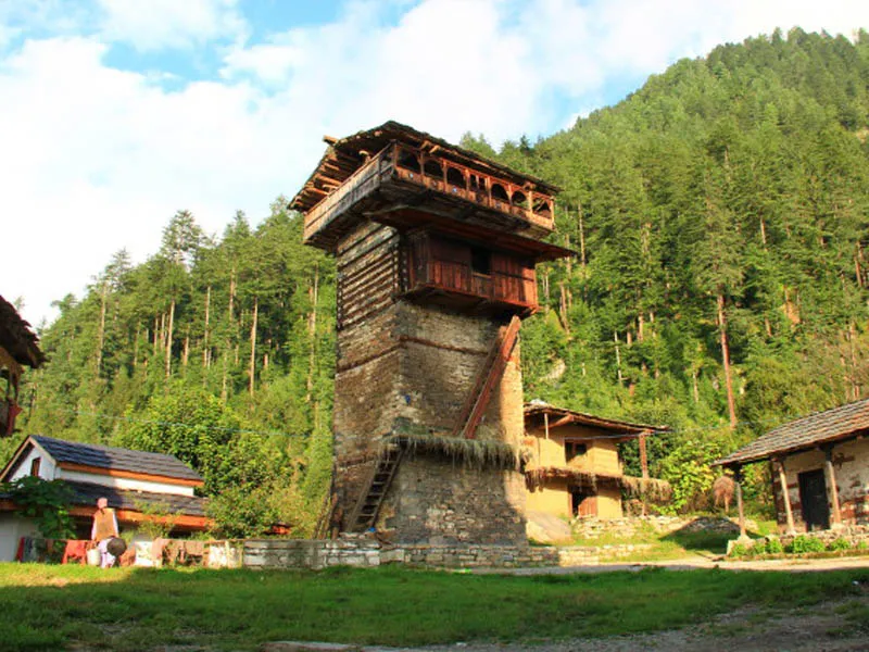Historic stone and timber tower architecture of Chehni Kothar fort nestled in a forested mountain village