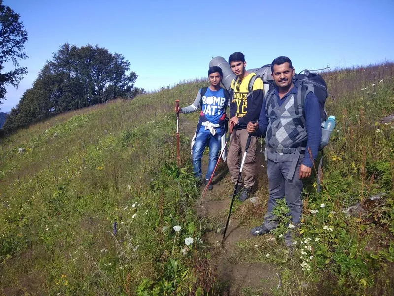 Group of hikers standing on a grassy mountain slope during Dehnasar Lake trek