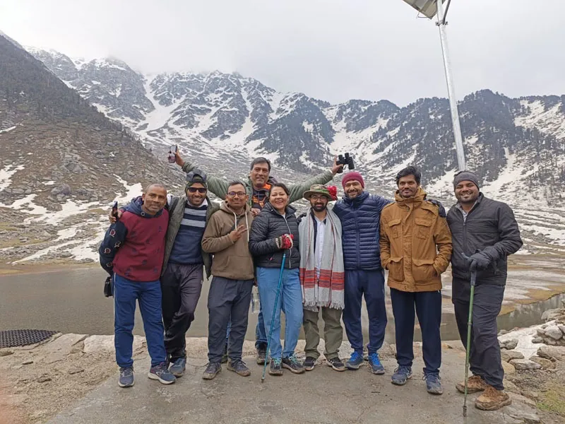 Trekking group posing happily near Lord Shiva temple on the banks of Kareri Lake