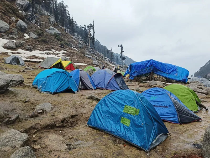 Alpine camping tents pitched among granite rocks on high-altitude meadow near Kareri Lake
