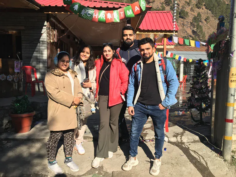 Group of young travelers posing outside a village cafe in Parvati Valley