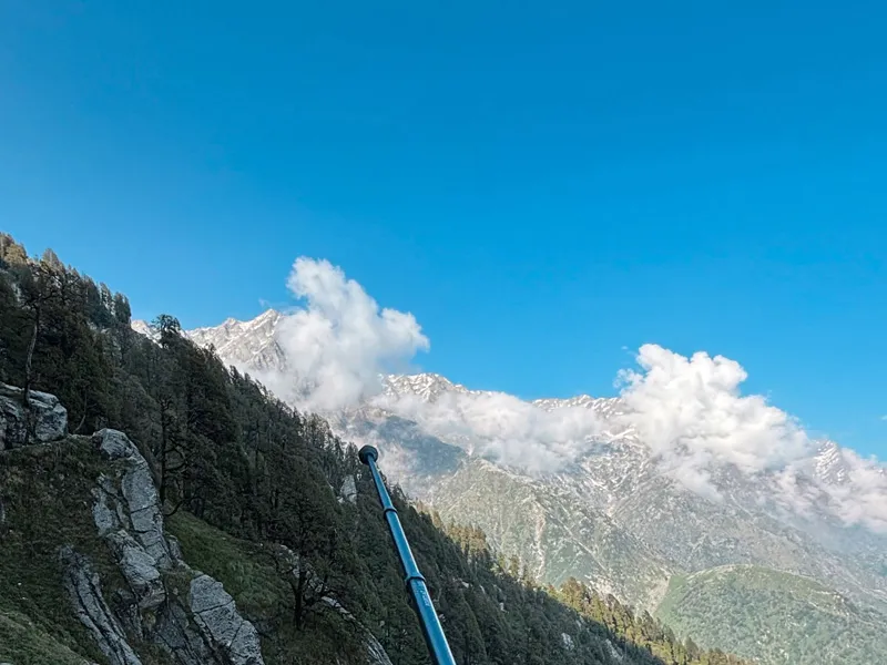Scenic mountain view with blue sky, passing clouds, and rugged snow-capped peaks