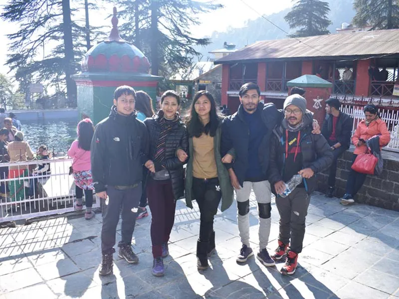 Group of tourists smiling and posing in the lively streets of Bhagsu market Dharamshala