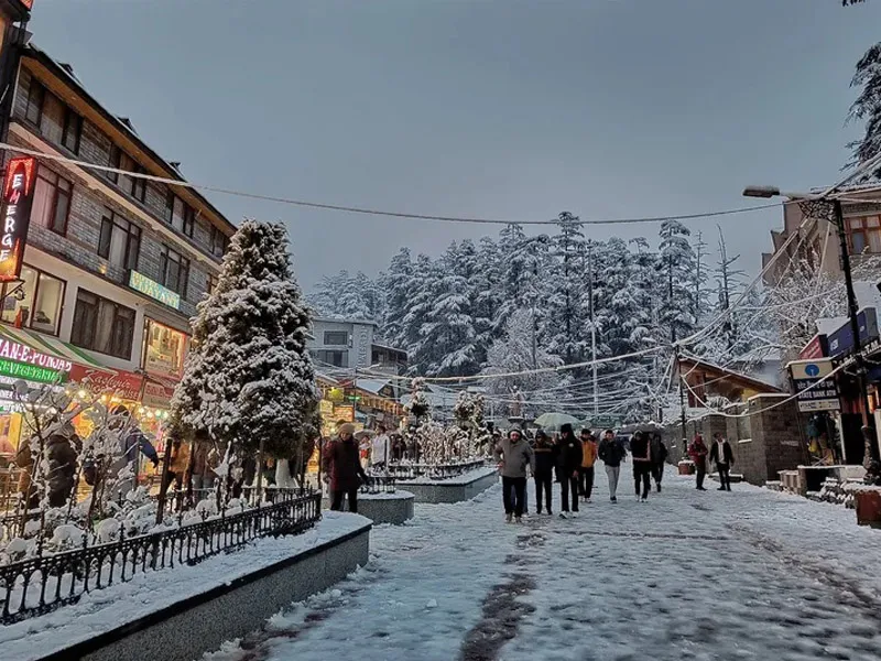 Mall Road Manali marketplace blanketed in fresh white snow during winter evening