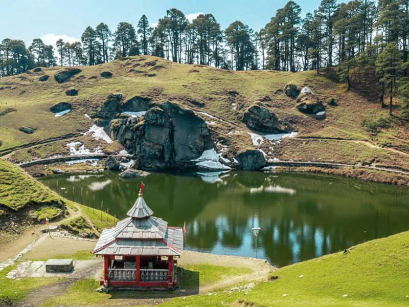 Ancient wooden temple on the tranquil green shore of sacred Serolsar Lake surrounded by alpine hills