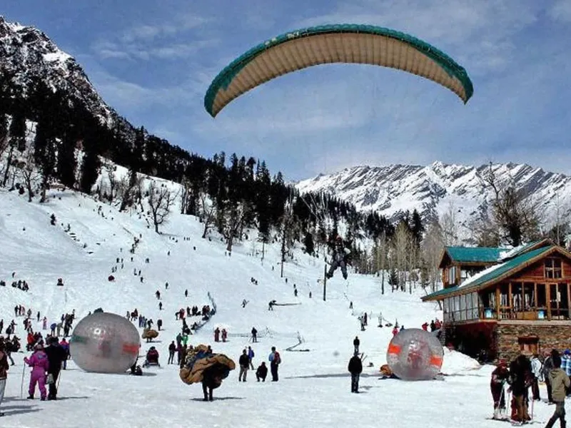 Paragliding and zorbing adventure activities on snow-covered slopes of Solang Valley Manali