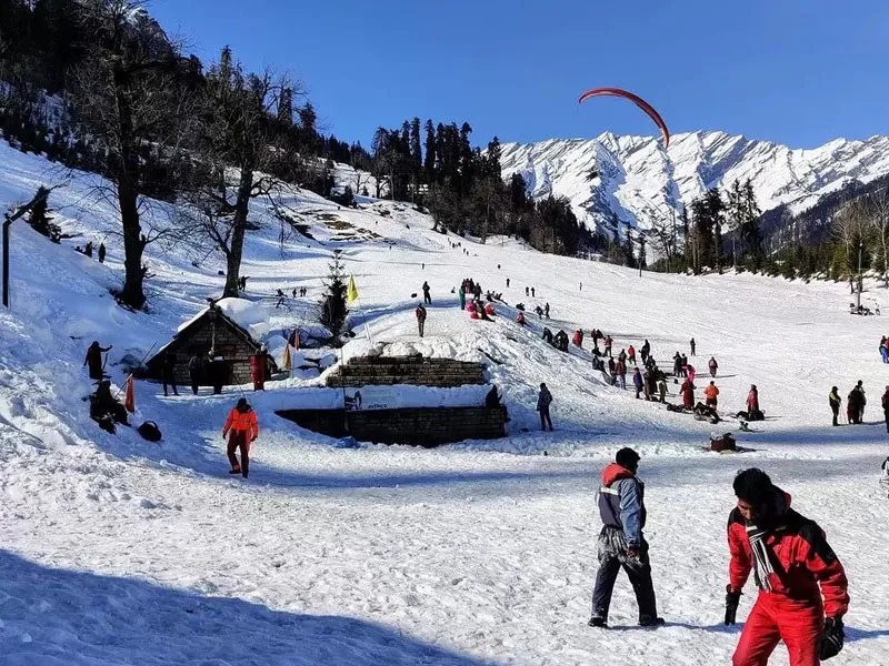 Tourists enjoying paragliding and snow activities on the slopes of Solang Valley Manali