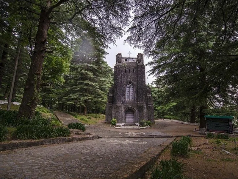 Gothic stone architecture of St. John in the Wilderness Church set within towering deodar trees near McLeodganj