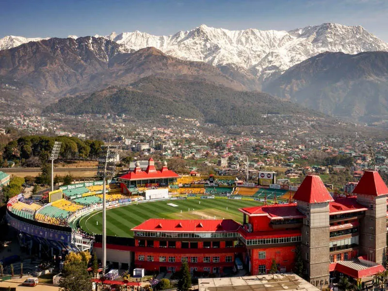High-angle view of scenic HPCA Cricket Stadium Dharamshala with towering snow-clad Dhauladhar mountains