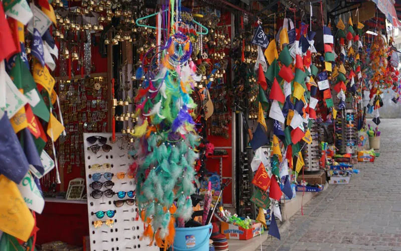 Tibetan souvenir shop with colorful prayer flags and handicrafts in McLeod Ganj market